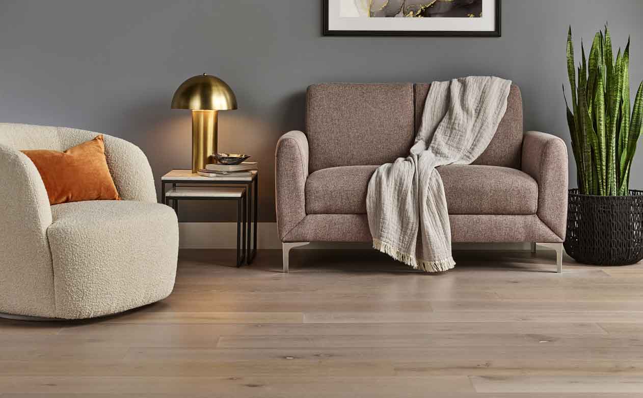 light hardwood flooring in a living room with love seat and accent chair